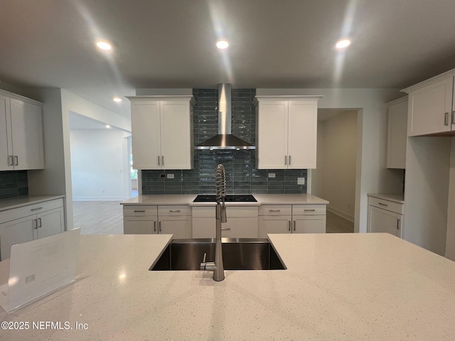 96088 Pirates Bluff Rd, Yulee, FL 32097 - kitchen featuring wall chimney range hood, decorative backsplash, white cabinets, black electric stovetop, and light stone counters