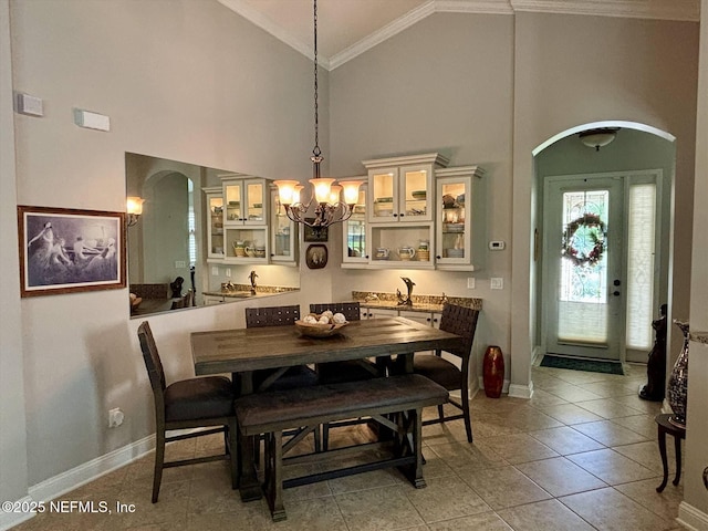 501 N Legacy Trl, Saint Augustine, FL 32092 - dining room featuring arched walkways, a chandelier, high vaulted ceiling, crown molding, and baseboards