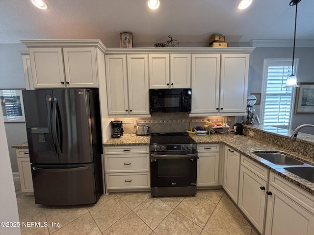 501 N Legacy Trl, Saint Augustine, FL 32092 - kitchen with black appliances, a sink, backsplash, light tile patterned floors, and light stone counters