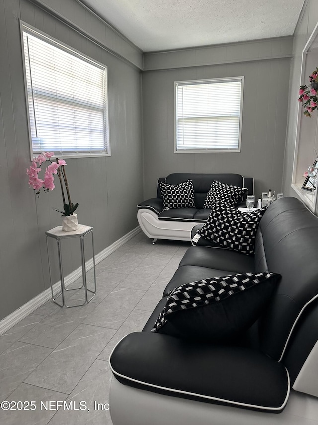 4040 Shasta Dr, Jacksonville, FL 32207 - living room featuring a textured ceiling, healthy amount of natural light, baseboards, and light tile patterned floors