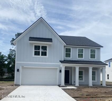 96100 Pirates Bluff Rd, Yulee, FL 32097 - view of front of property with covered porch, an attached garage, concrete driveway, and board and batten siding