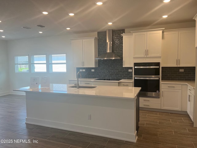 96100 Pirates Bluff Rd, Yulee, FL 32097 - kitchen with wall chimney exhaust hood, dark wood finished floors, double oven, decorative backsplash, and recessed lighting