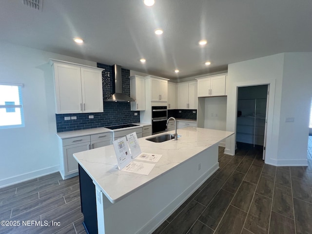 96100 Pirates Bluff Rd, Yulee, FL 32097 - kitchen featuring wall chimney exhaust hood, wood tiled floors, black appliances, white cabinets, and tasteful backsplash