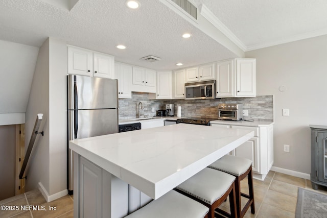 1165 Beach Walker Rd, Fernandina Beach, FL 32034 - kitchen featuring appliances with stainless steel finishes, a sink, tasteful backsplash, white cabinetry, and recessed lighting