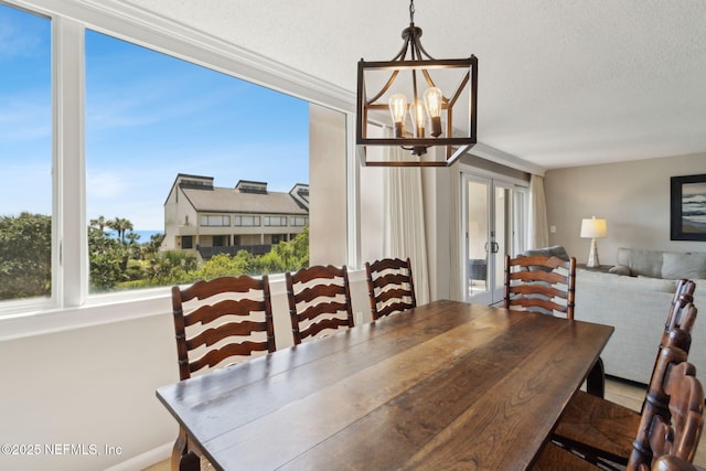 1165 Beach Walker Rd, Fernandina Beach, FL 32034 - dining room featuring french doors, a chandelier, a textured ceiling, and ornamental molding