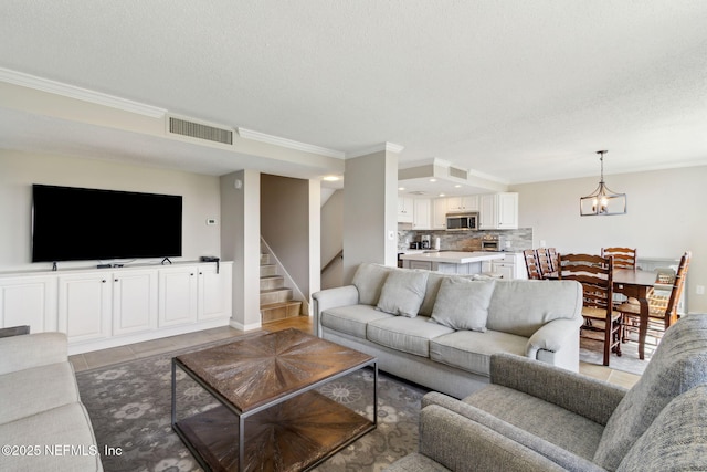 1165 Beach Walker Rd, Fernandina Beach, FL 32034 - living area with crown molding, a textured ceiling, stairs, light tile patterned floors, and a chandelier