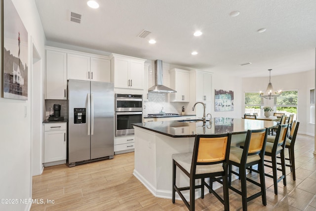 264 Windermere Way, Saint Augustine, FL 32095 - kitchen with stainless steel appliances, wall chimney range hood, a sink, dark countertops, and tasteful backsplash
