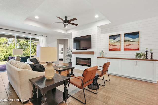 264 Windermere Way, Saint Augustine, FL 32095 - living room with a raised ceiling, a ceiling fan, a fireplace, recessed lighting, and light wood-style flooring