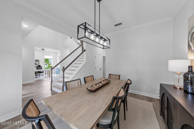 6547 Burnham Cir, Ponte Vedra Beach, FL 32082 - dining space featuring wood finished floors, baseboards, ornamental molding, a ceiling fan, and stairs