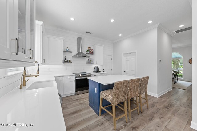 6547 Burnham Cir, Ponte Vedra Beach, FL 32082 - kitchen featuring stainless steel electric range, wall chimney exhaust hood, a sink, ornamental molding, and a kitchen island