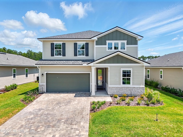 107 Seasons Ct, Saint Augustine, FL 32092 - view of front facade featuring board and batten siding, decorative driveway, an attached garage, a front yard, and stone siding