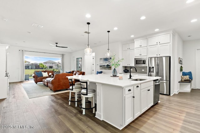 638 Windley Dr, Saint Augustine, FL 32092 - kitchen featuring stainless steel appliances, a sink, wood finished floors, open floor plan, and a kitchen island with sink