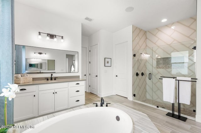 638 Windley Dr, Saint Augustine, FL 32092 - bathroom with vanity, a shower stall, wood finished floors, and a bathtub