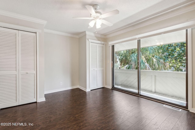 3036 Sea Marsh Rd, Fernandina Beach, FL 32034 - unfurnished bedroom with access to exterior, dark wood-type flooring, two closets, ornamental molding, and baseboards