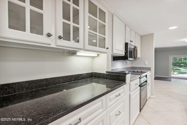 3036 Sea Marsh Rd, Fernandina Beach, FL 32034 - kitchen featuring oven, white cabinets, glass insert cabinets, light tile patterned floors, and recessed lighting