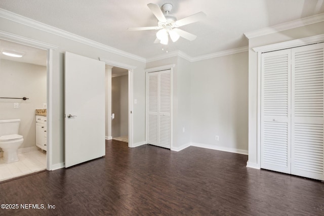 3036 Sea Marsh Rd, Fernandina Beach, FL 32034 - unfurnished bedroom with multiple closets, dark wood-style floors, crown molding, baseboards, and ensuite bathroom