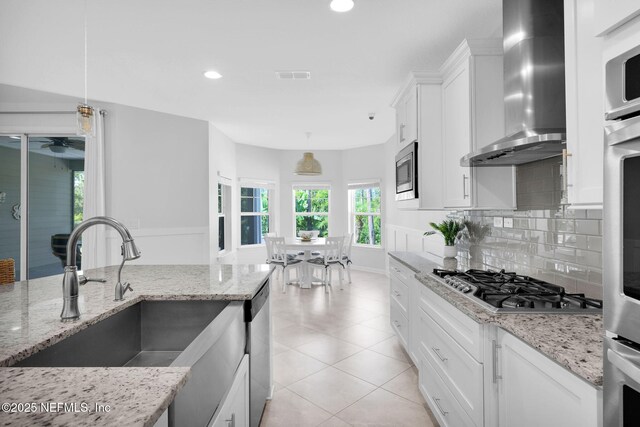 25 Carnauba Way, Jacksonville, FL 32081 - kitchen with wall chimney exhaust hood, stainless steel appliances, a sink, white cabinetry, and recessed lighting
