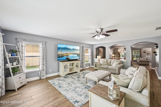 145 Thornloe Dr, Saint Johns, FL 32259 - living room with arched walkways, a ceiling fan, light wood-style flooring, baseboards, and a textured ceiling