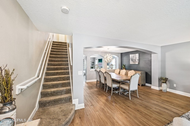 145 Thornloe Dr, Saint Johns, FL 32259 - dining area featuring arched walkways, light wood-style flooring, stairs, a chandelier, and baseboards
