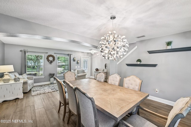 145 Thornloe Dr, Saint Johns, FL 32259 - dining space with a chandelier, wood finished floors, baseboards, and a textured ceiling