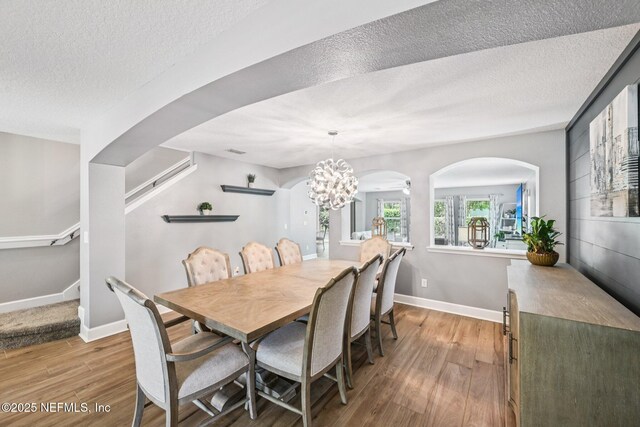 145 Thornloe Dr, Saint Johns, FL 32259 - dining area with wood finished floors, arched walkways, stairway, a textured ceiling, and baseboards