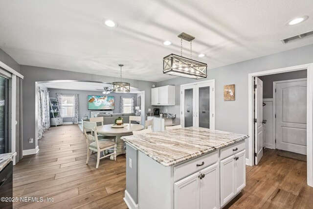 145 Thornloe Dr, Saint Johns, FL 32259 - kitchen featuring white cabinets, recessed lighting, wood finished floors, a center island, and hanging light fixtures