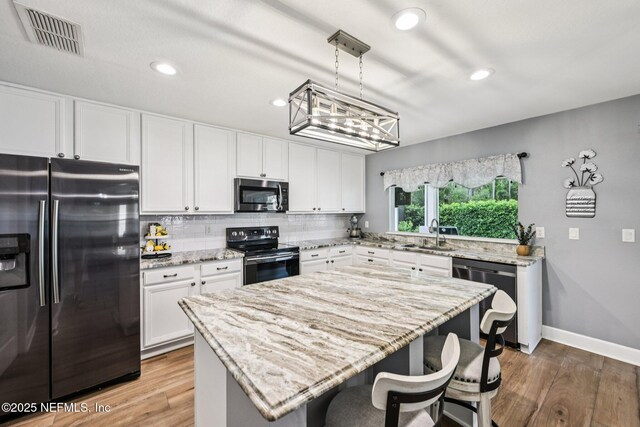 145 Thornloe Dr, Saint Johns, FL 32259 - kitchen with stainless steel appliances, a sink, white cabinetry, backsplash, and light wood-type flooring