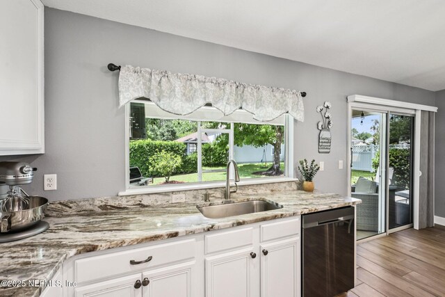145 Thornloe Dr, Saint Johns, FL 32259 - kitchen with a sink, dishwasher, light wood-style floors, and white cabinetry