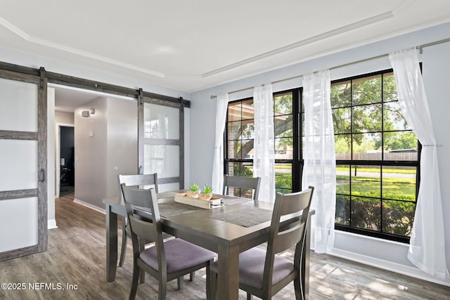 147 Quarton Dr, Orange Park, FL 32073 - dining area featuring a barn door, wood finished floors, and baseboards