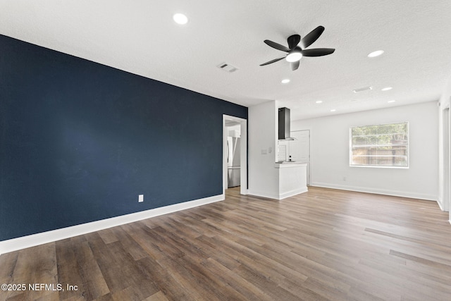 9007 7th Ave, Jacksonville, FL 32208 - unfurnished living room featuring ceiling fan, wood finished floors, baseboards, recessed lighting, and a textured ceiling