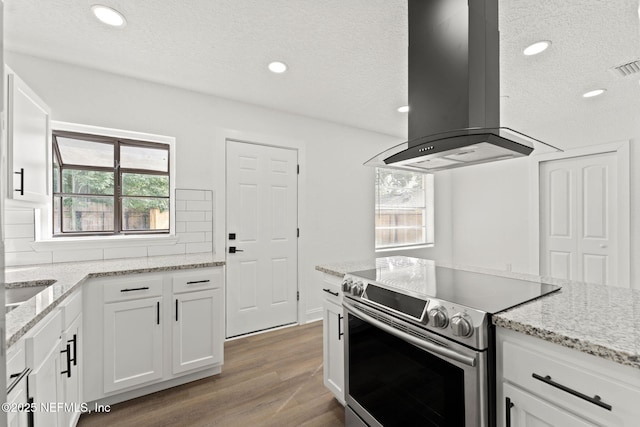 9007 7th Ave, Jacksonville, FL 32208 - kitchen featuring electric range, island exhaust hood, healthy amount of natural light, wood finished floors, and recessed lighting