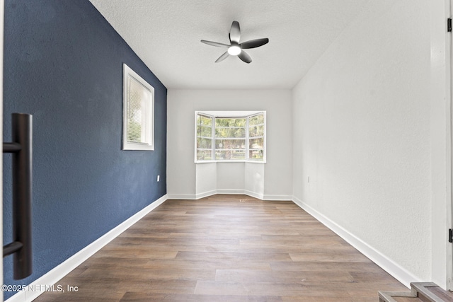 9007 7th Ave, Jacksonville, FL 32208 - unfurnished room featuring ceiling fan, wood finished floors, a textured ceiling, baseboards, and a textured wall