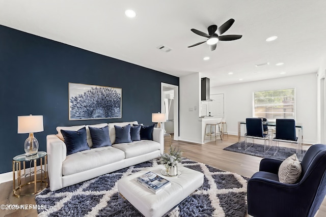9007 7th Ave, Jacksonville, FL 32208 - living room with an accent wall, wood finished floors, a ceiling fan, baseboards, and recessed lighting