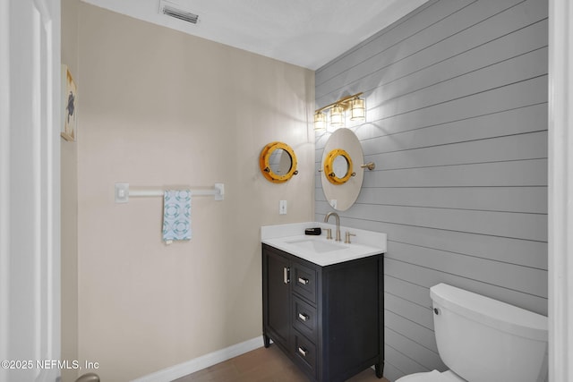 2898 Ocean Shore Blvd Unit 4020, Ormond Beach, FL 32176 - half bathroom with toilet, vanity, wooden walls, baseboards, and wood finished floors