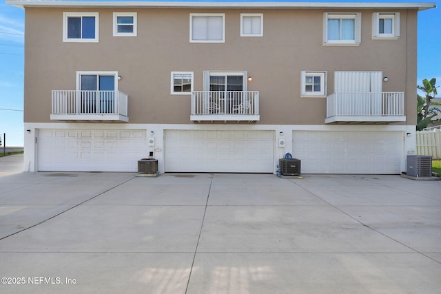 2898 Ocean Shore Blvd Unit 4020, Ormond Beach, FL 32176 - rear view of property with an attached garage, stucco siding, central AC, and driveway