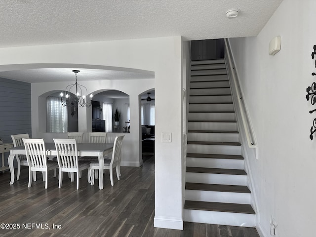 305 Carriage Hill Ct, Saint Johns, FL 32259 - stairway with arched walkways, a textured ceiling, wood finished floors, a chandelier, and baseboards