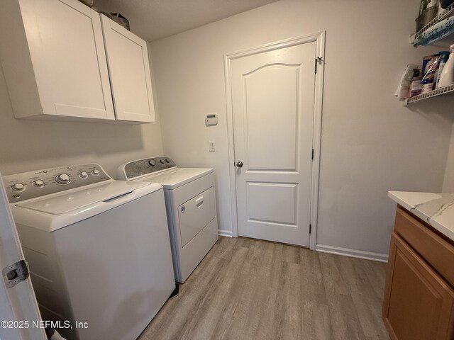 305 Carriage Hill Ct, Saint Johns, FL 32259 - laundry area featuring light wood-type flooring, washing machine and clothes dryer, and cabinet space
