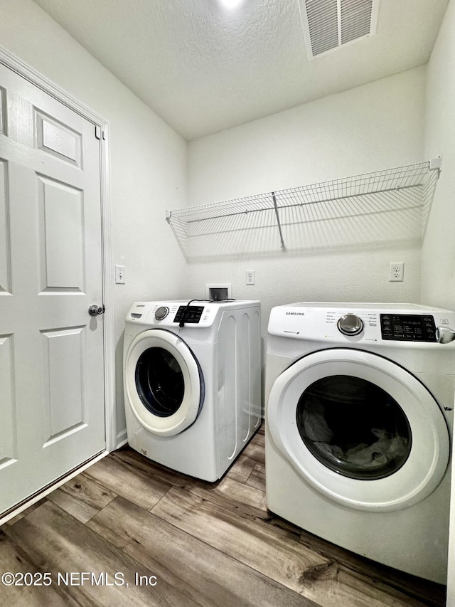 403 Boulder Ln, Jacksonville, FL 32259 - laundry area featuring independent washer and dryer, wood finished floors, and a textured ceiling