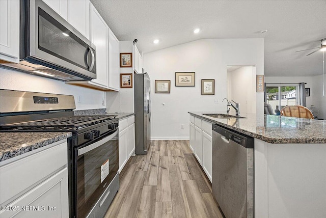 403 Boulder Ln, Jacksonville, FL 32259 - kitchen with stainless steel appliances, a sink, light wood finished floors, dark stone countertops, and lofted ceiling