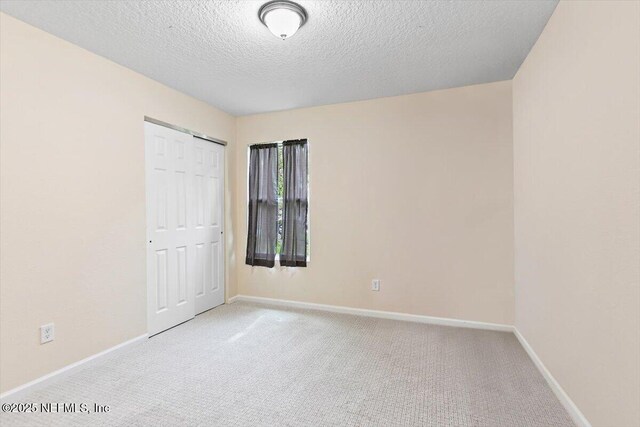 4116 Adirolf Rd, Jacksonville, FL 32207 - unfurnished bedroom with carpet flooring, baseboards, a closet, and a textured ceiling