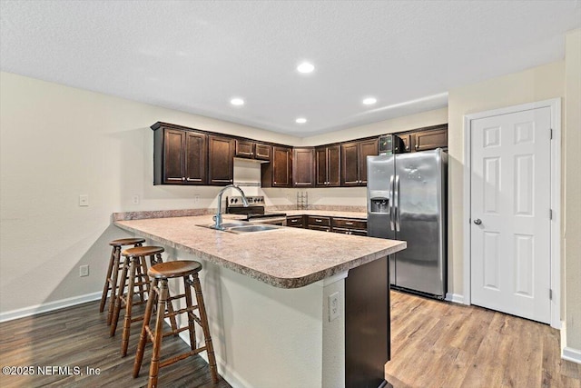 4116 Adirolf Rd, Jacksonville, FL 32207 - kitchen featuring stainless steel fridge with ice dispenser, dark brown cabinetry, a sink, light wood-style floors, and recessed lighting