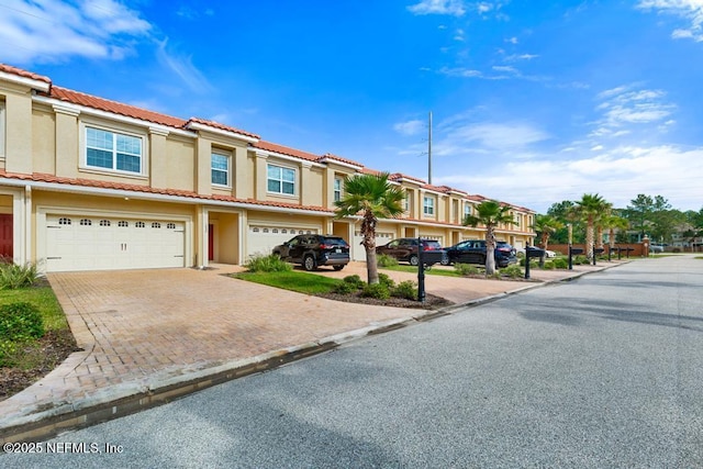 1684 Sanctuary Way, Fleming Island, FL 32003 - view of property featuring a residential view, decorative driveway, stucco siding, an attached garage, and a tiled roof