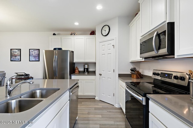 1684 Sanctuary Way, Fleming Island, FL 32003 - kitchen featuring appliances with stainless steel finishes, a sink, light wood finished floors, recessed lighting, and white cabinetry