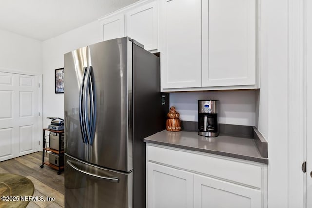 1684 Sanctuary Way, Fleming Island, FL 32003 - kitchen with freestanding refrigerator, wood finished floors, white cabinetry, and dark countertops