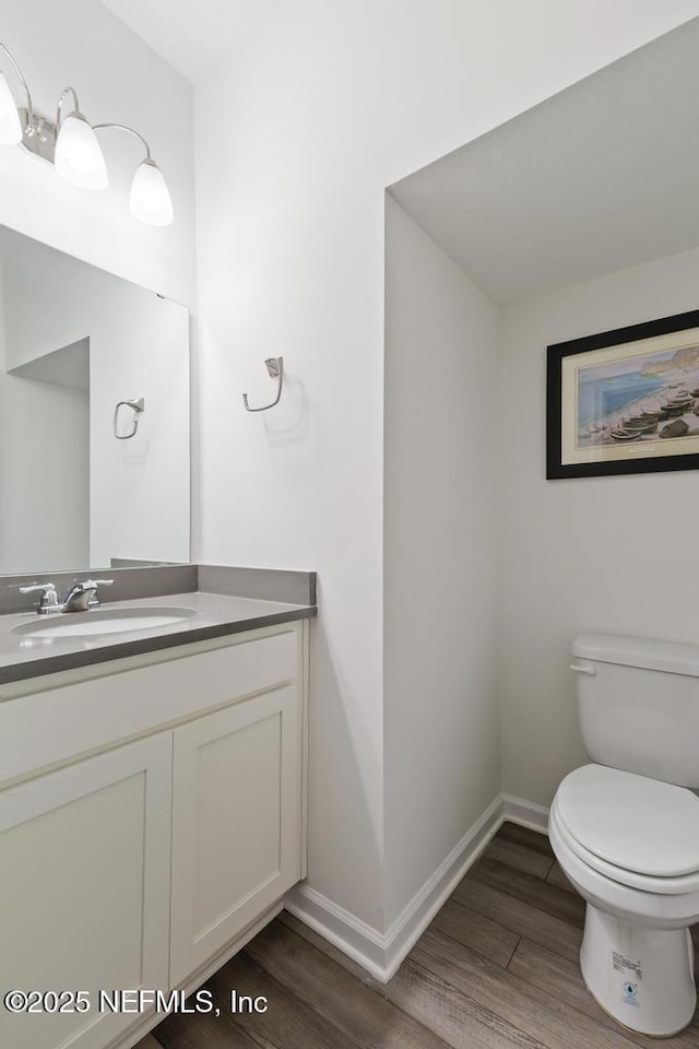 1684 Sanctuary Way, Fleming Island, FL 32003 - bathroom with vanity, toilet, wood finished floors, and baseboards