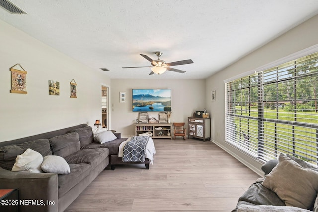 884 Live Oak Ln, Fleming Island, FL 32003 - living room featuring light wood finished floors, ceiling fan, and a textured ceiling