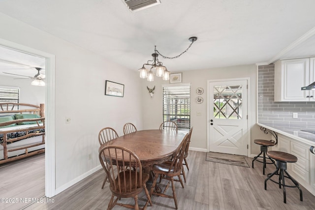 884 Live Oak Ln, Fleming Island, FL 32003 - dining room with light wood-type flooring, a chandelier, and a ceiling fan