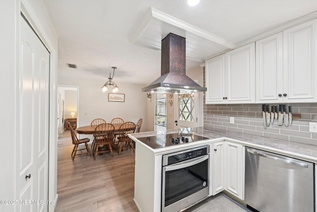 884 Live Oak Ln, Fleming Island, FL 32003 - kitchen featuring appliances with stainless steel finishes, extractor fan, white cabinets, light wood-style floors, and backsplash