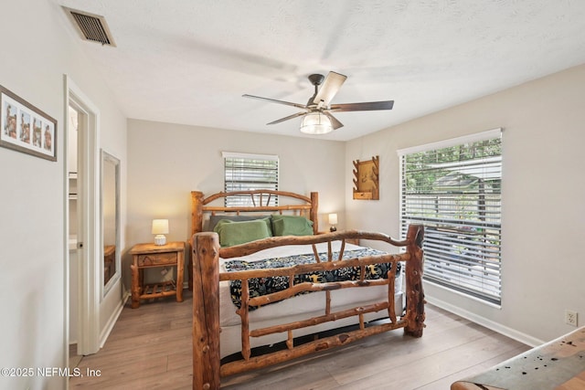 884 Live Oak Ln, Fleming Island, FL 32003 - bedroom with wood finished floors, multiple windows, ceiling fan, and a textured ceiling