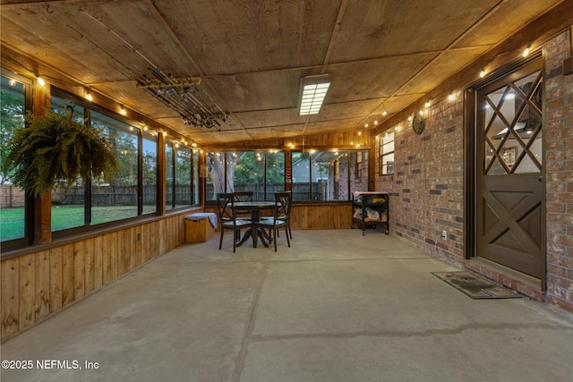 884 Live Oak Ln, Fleming Island, FL 32003 - sunroom with concrete flooring, brick wall, wood walls, and wooden ceiling